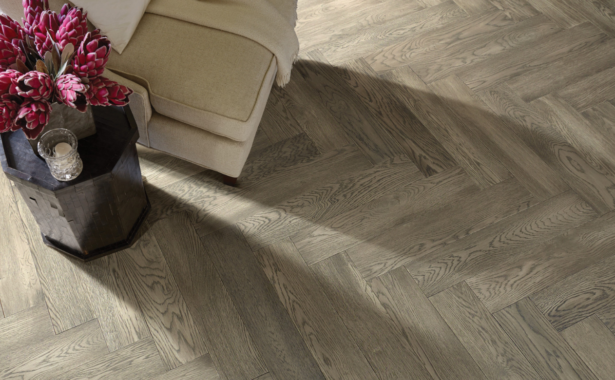 chevron layout hardwood floors in sitting area with cream armchair